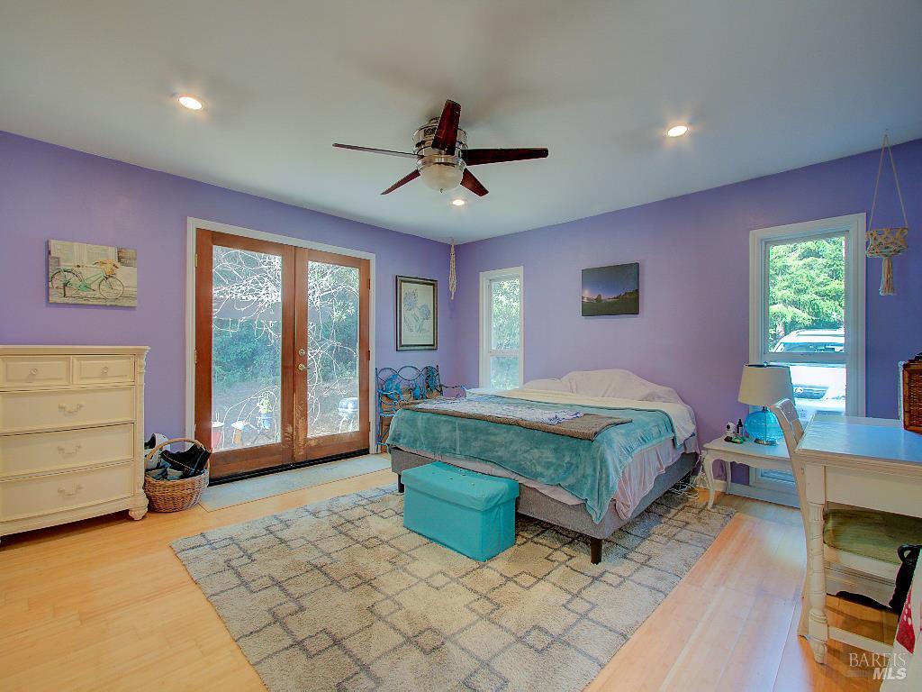31191 Turner Road Fort Bragg, CA 95437 - Photo 15 of 36 a spacious bedroom with a bed a dresser and a chandelier