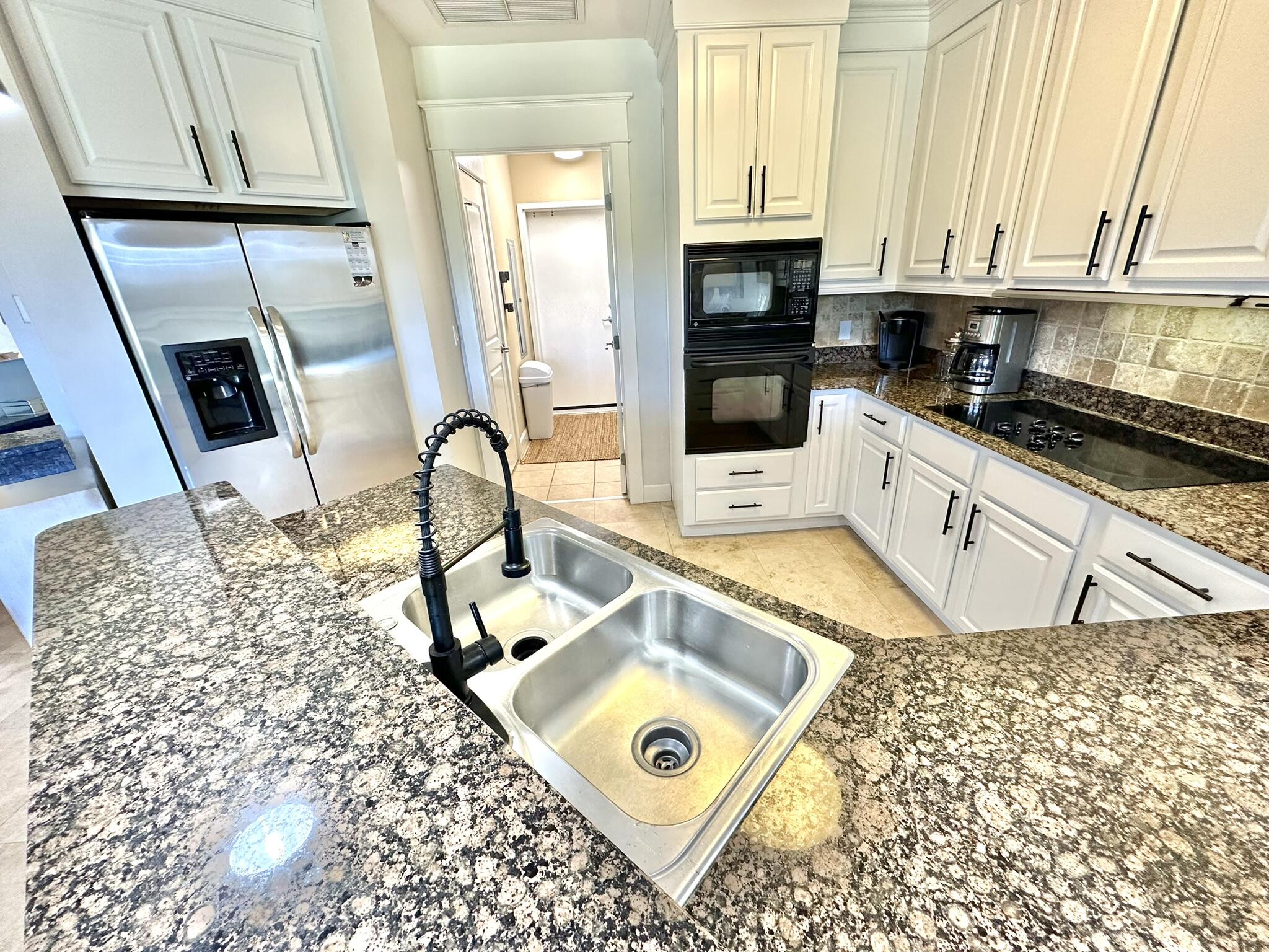 5353 Pine Ridge Lane, Unit 5353 Miramar Beach, FL 32550 - Photo 14 of 62 a kitchen with granite countertop a stove a sink and a microwave