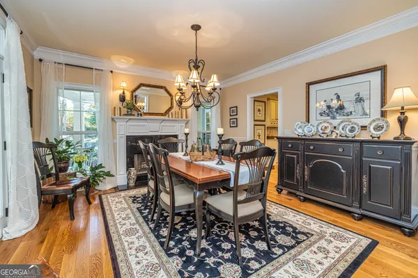 a dining room with furniture a chandelier and wooden floor
