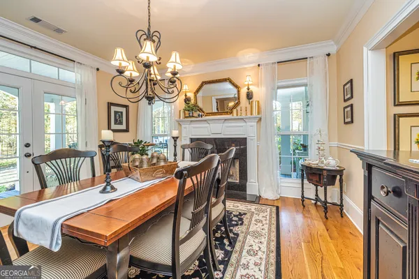 a view of a dining room with furniture a chandelier and wooden floor