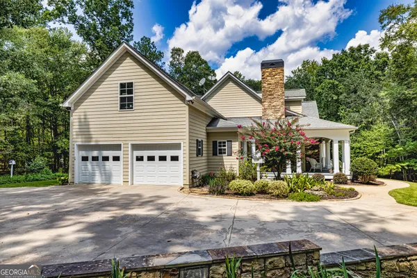 a front view of a house with a yard and trees