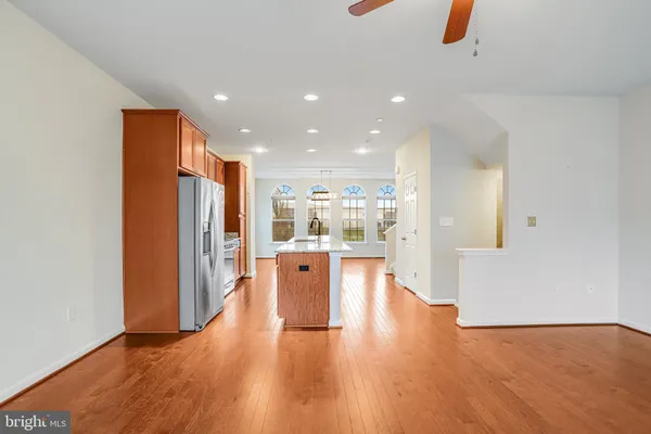 a view of kitchen with stainless steel appliances refrigerator stove and wooden floor