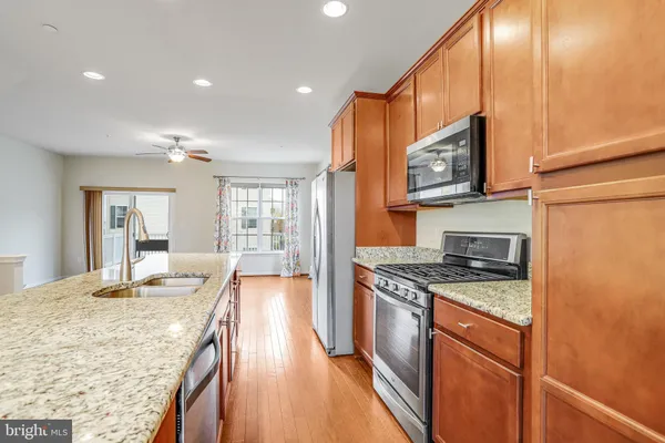 a kitchen with stainless steel appliances granite countertop a sink stove and refrigerator