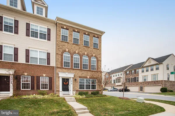 front view of a brick house with a yard