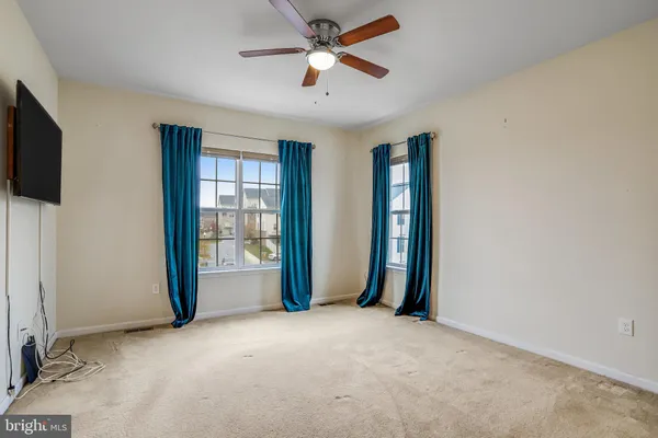 a view of an empty room with a window and a kitchen
