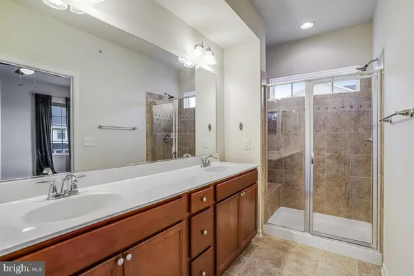 a bathroom with a shower sink and mirror