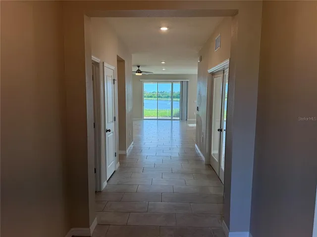 a view of hallway with a bathroom and a tub