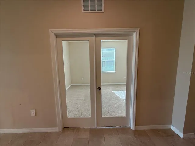 an empty room with a window and a fan