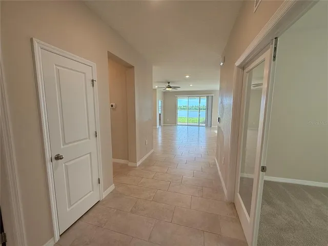an empty room with closet and a chandelier fan