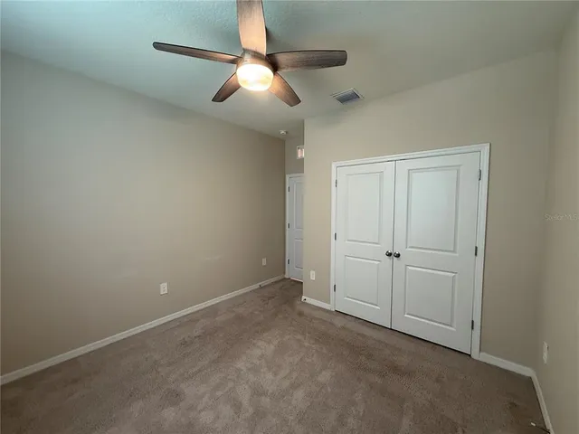 an empty room with closet and windows