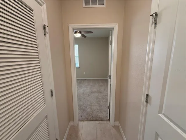 a view of an empty room and a ceiling fan