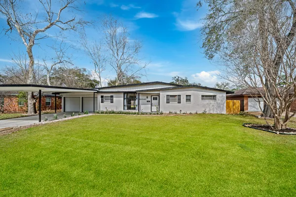 a front view of a house with a garden