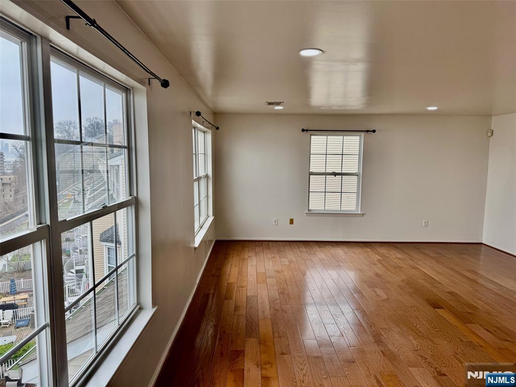 34 Bergen Ridge Road, Unit 2 North Bergen, NJ 07047 - Photo 8 of 41 an empty room with wooden floor and windows