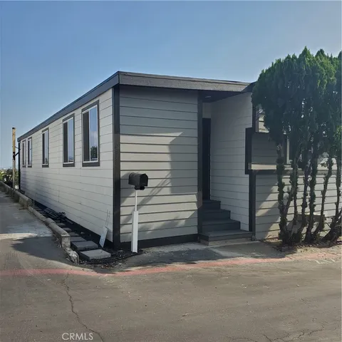 a view of a house with a small yard and wooden fence