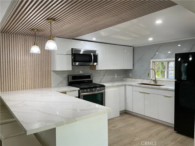 a kitchen with stainless steel appliances a stove sink microwave and cabinets