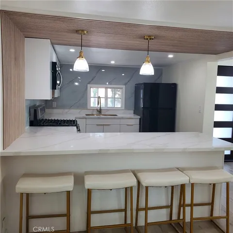 a kitchen with a dining table a sink and cabinets