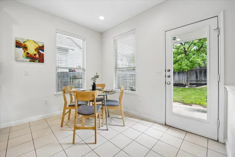 a dining room with furniture and a floor to ceiling window