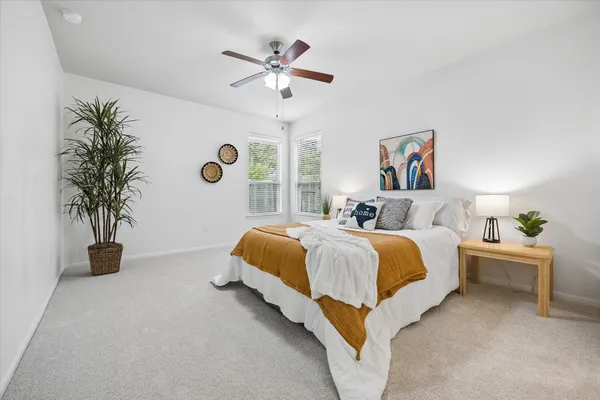 a spacious bedroom with a bed and a chandelier