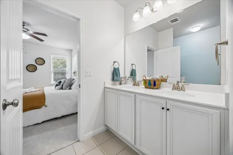 a bathroom with a double vanity sink mirror and shower