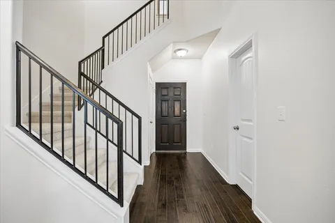 a view of staircase with wooden floor and white walls