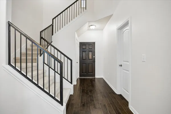 a view of staircase with wooden floor and white walls