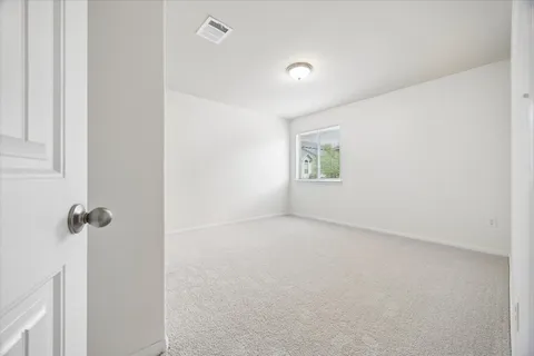 an empty room with closet and ceiling fan