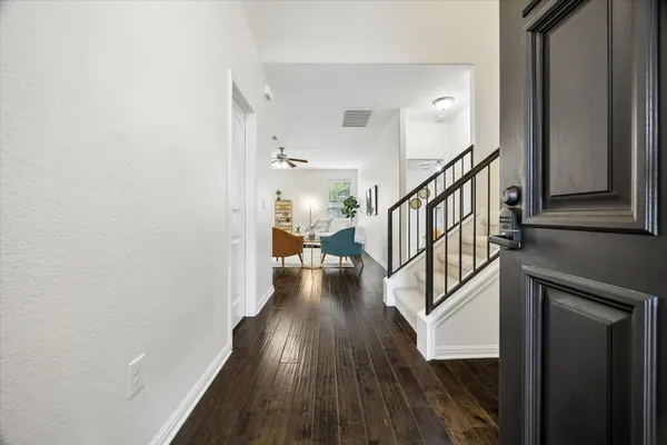 a view of a hallway with wooden floor and staircase