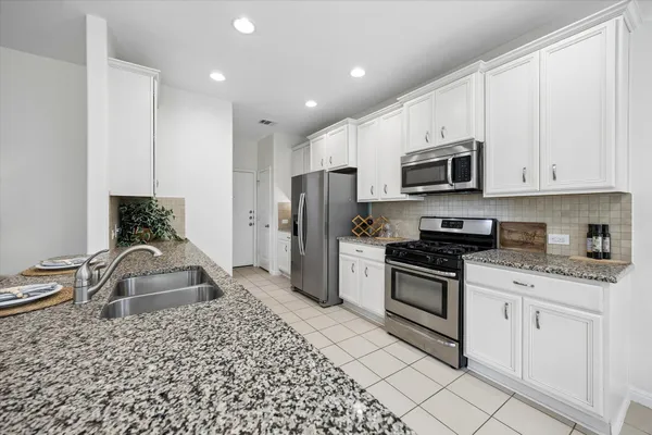 a kitchen with stainless steel appliances granite countertop a stove a sink and a refrigerator