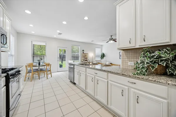 a kitchen with granite countertop white cabinets and white appliances