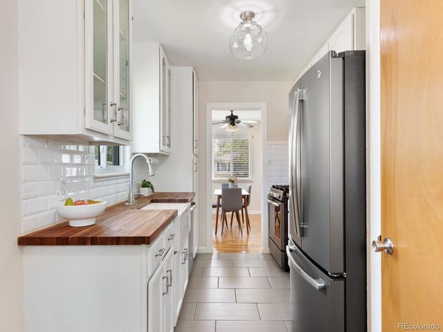 a kitchen with granite countertop a sink stove and refrigerator