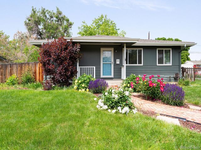 a front view of a house with a yard and potted plants