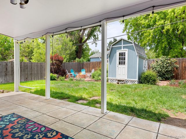 a view of backyard with large trees and plants
