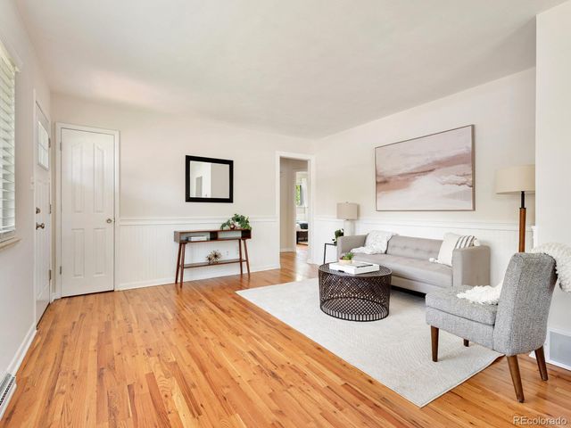 a living room with furniture and a wooden floor