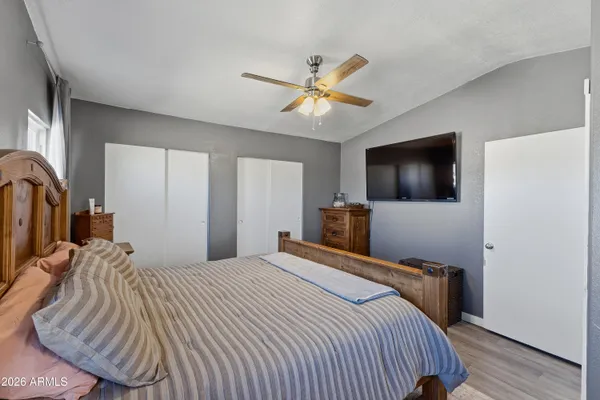 a bedroom with a bed and a flat tv screen on dresser