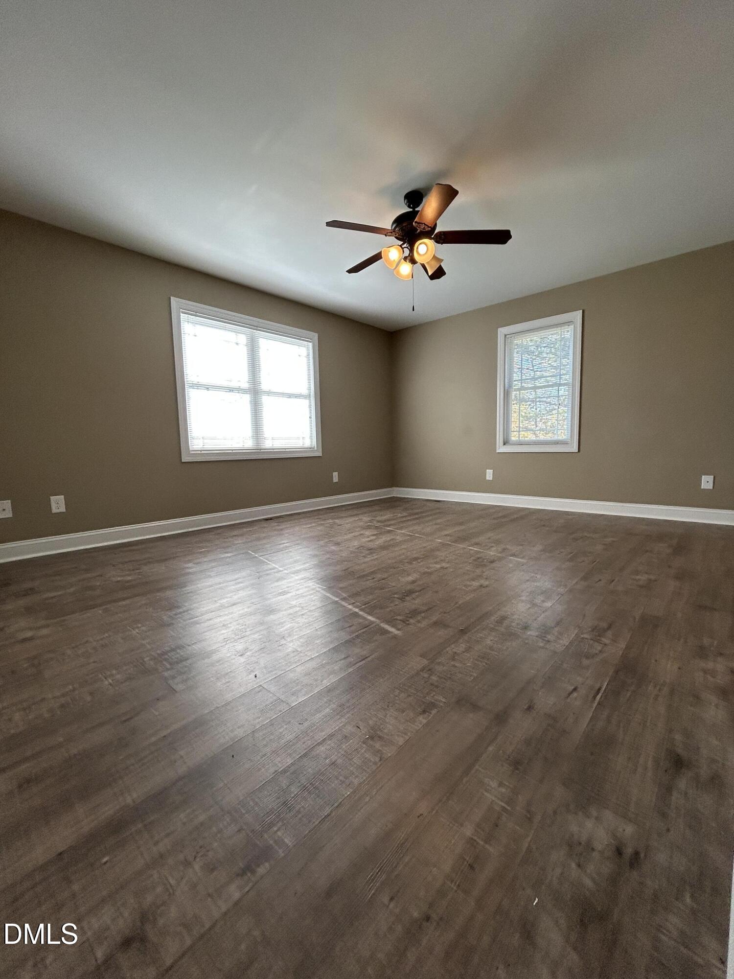 3105 Tump Wilkins Road Stem, NC 27581 - Photo 18 of 30 an empty room with windows and a ceiling fan