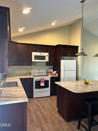 a kitchen with stainless steel appliances a sink a stove top oven a counter space and cabinets