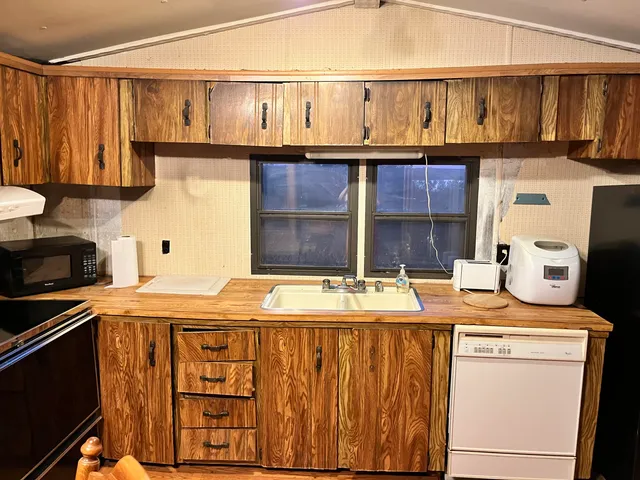 a kitchen with stainless steel appliances granite countertop a sink stove and cabinets