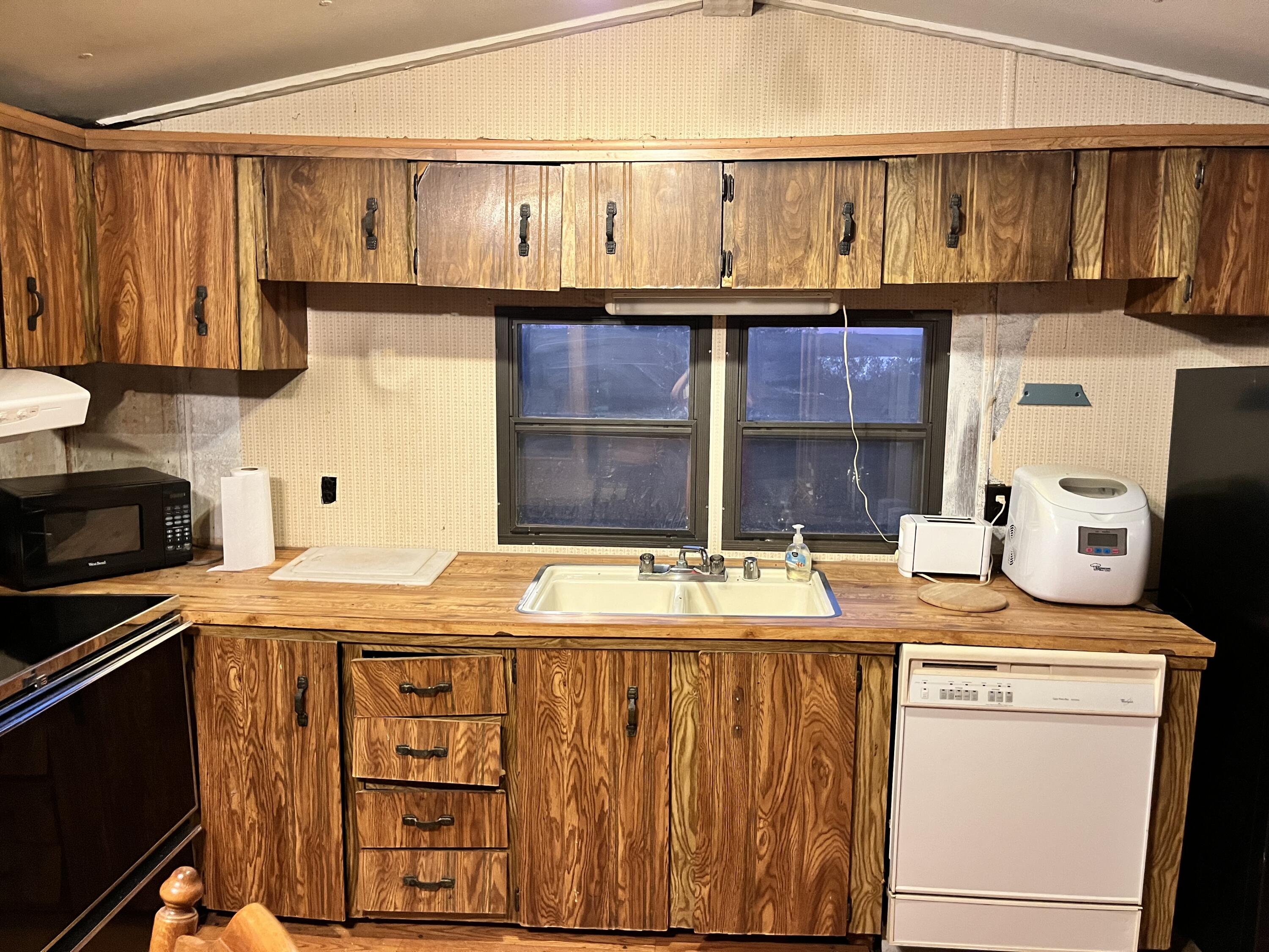329 Spur Road Spur, TX 79370 - Photo 11 of 17 a kitchen with stainless steel appliances granite countertop a sink stove and cabinets