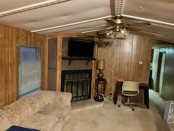 a living room with furniture a flat screen tv and a fireplace