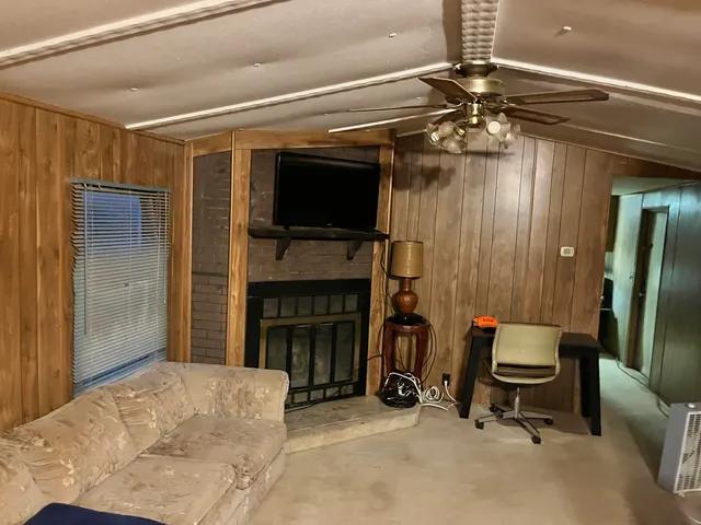 a living room with furniture a flat screen tv and a fireplace