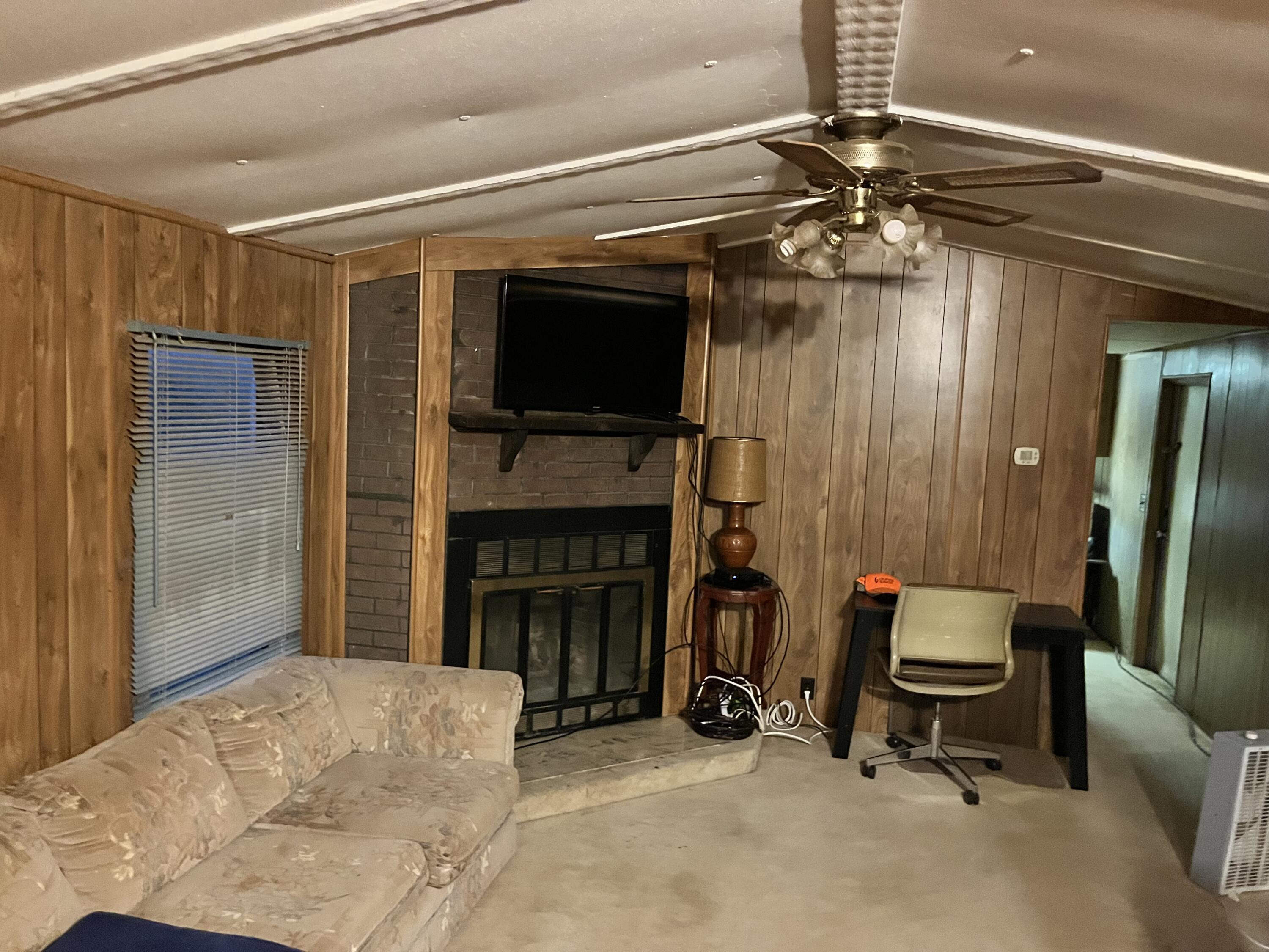 329 Spur Road Spur, TX 79370 - Photo 7 of 17 a living room with furniture a flat screen tv and a fireplace