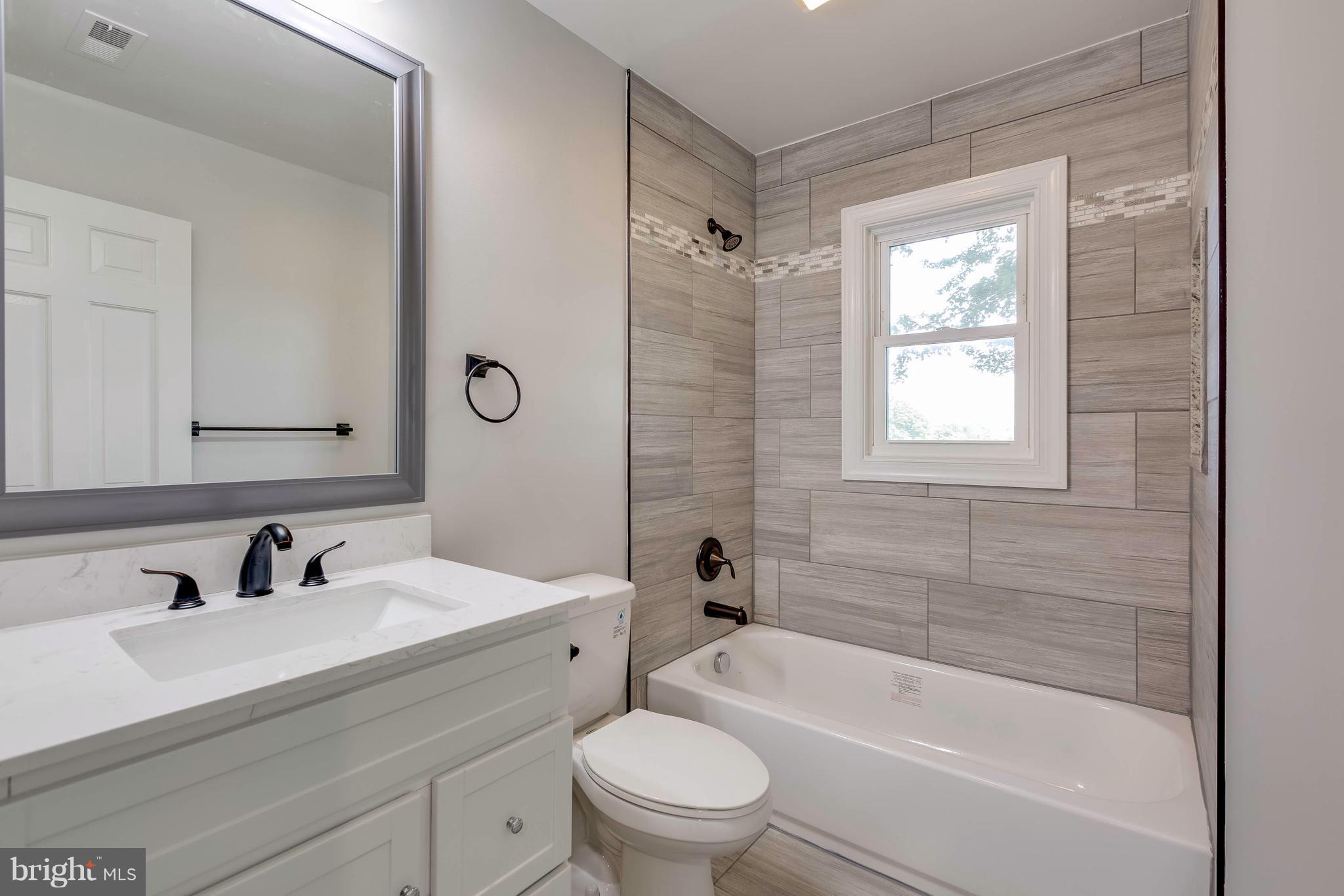 23435 Peach Tree Road Clarksburg, MD 20871 - Photo 11 of 26 a bathroom with a bathtub shower sink vanity mirror and toilet