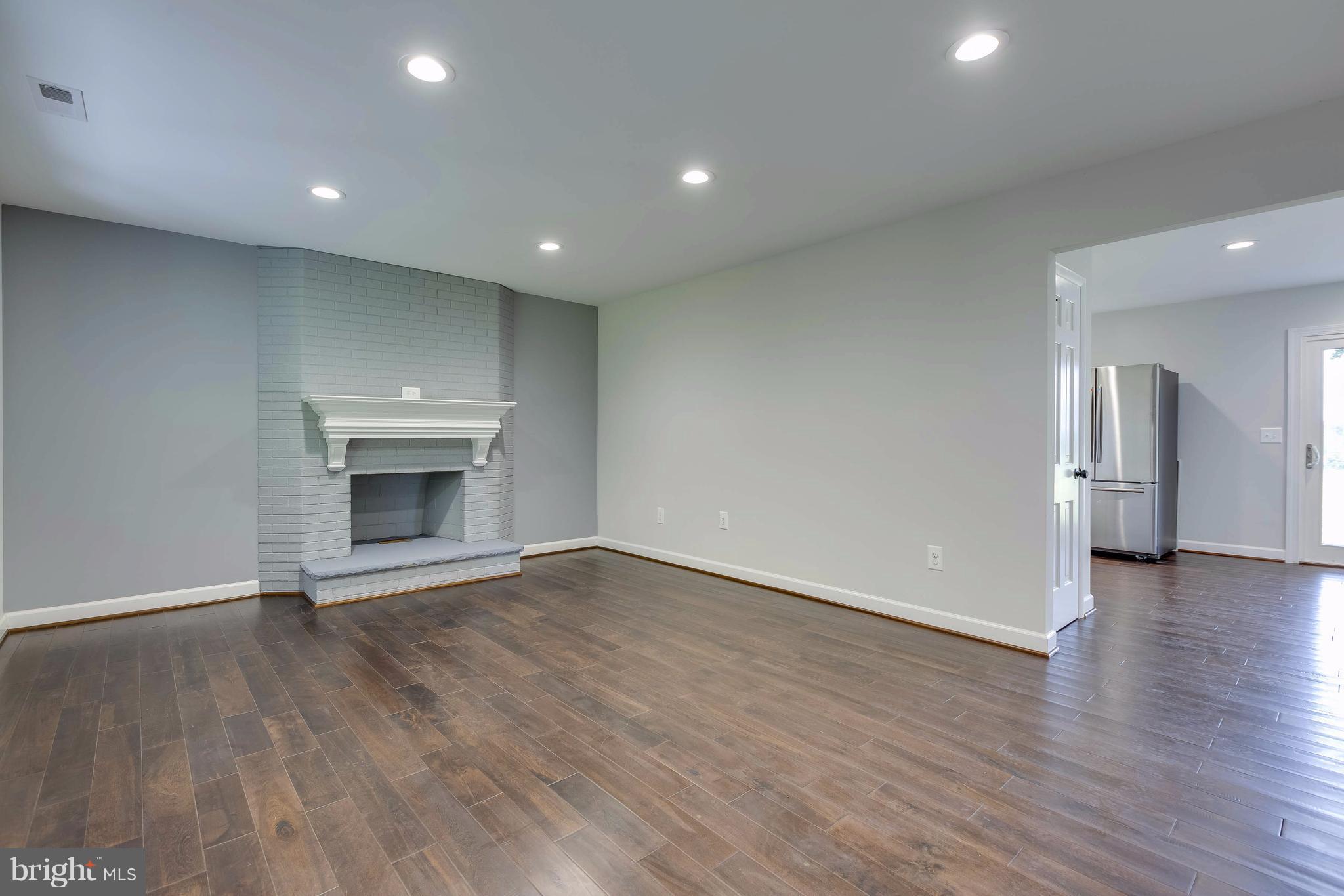 23435 Peach Tree Road Clarksburg, MD 20871 - Photo 3 of 26 a view of empty room with wooden floor and fireplace