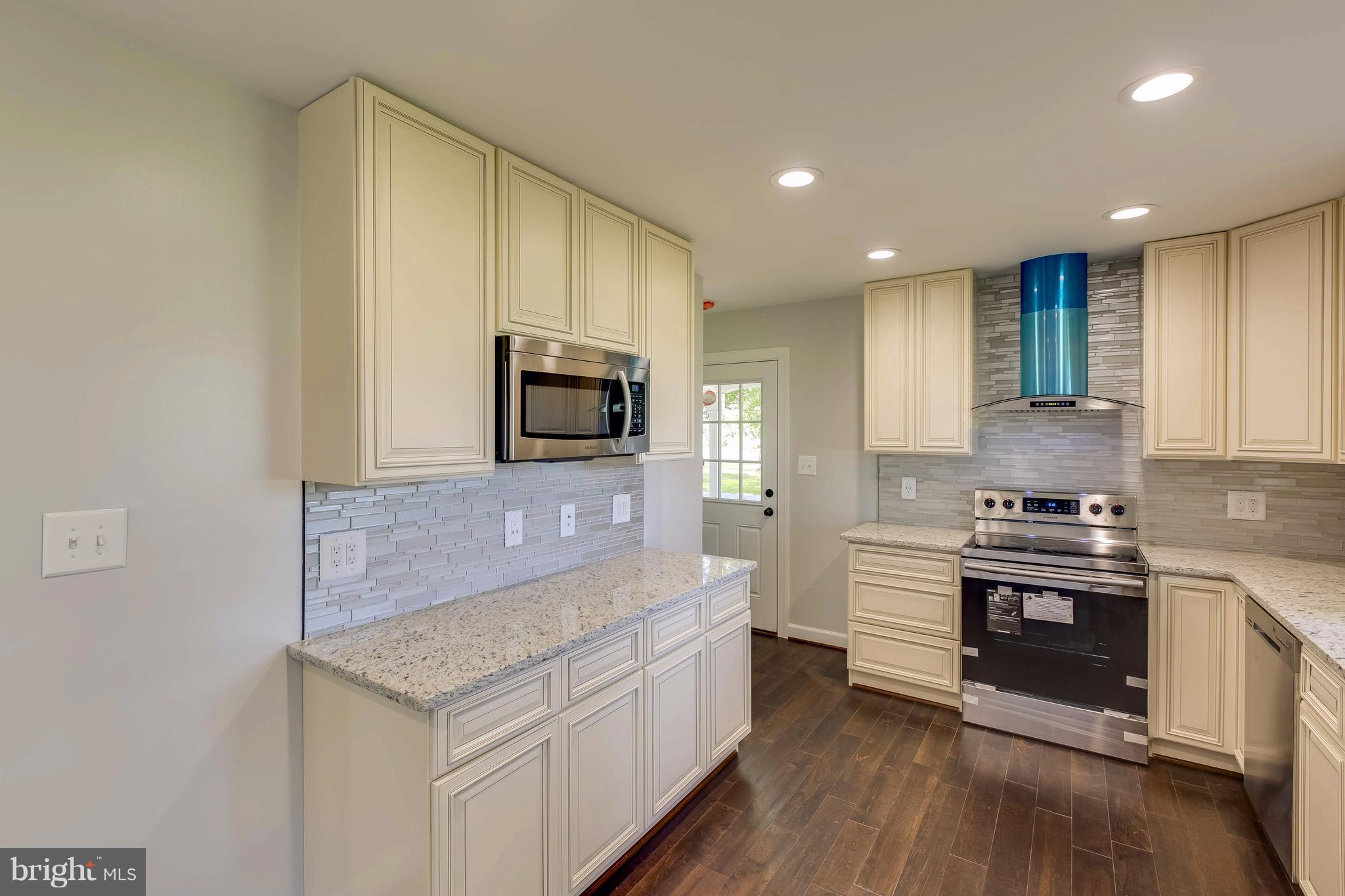 23435 Peach Tree Road Clarksburg, MD 20871 - Photo 7 of 26 a kitchen with stainless steel appliances granite countertop a stove and a microwave