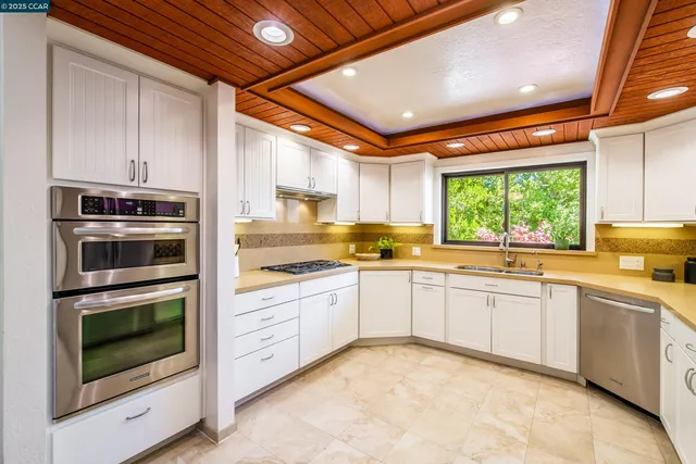a kitchen with granite countertop a sink stainless steel appliances and cabinets