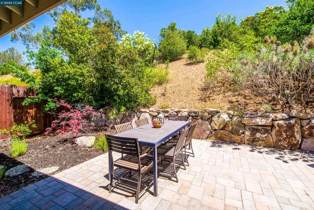 a view of a patio with table and chairs and couches with wooden floor and fence