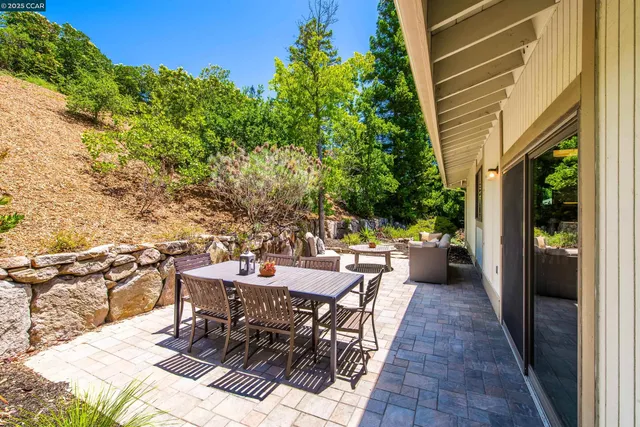 a view of a patio with table and chairs and potted plants