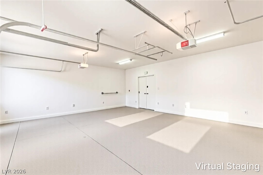 7119 Arabian Ridge Street Las Vegas, NV 89131 - Photo 62 of 73 A spacious, clean garage featuring an overhead door track system and bright overhead lighting.