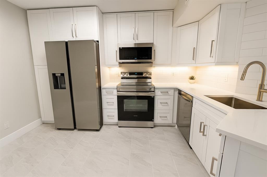 a kitchen with a stove sink and refrigerator