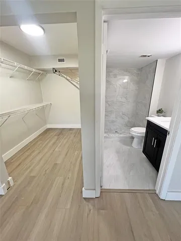 wooden floor in an empty room with a bathroom